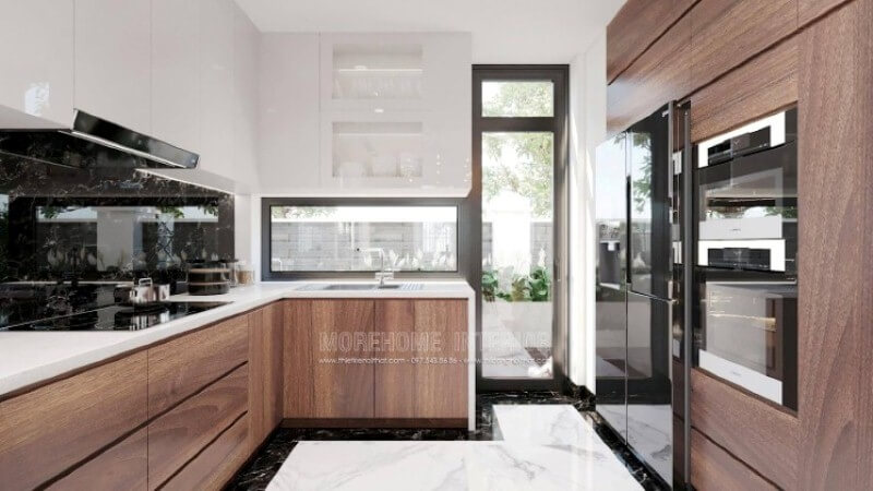 Là một trong những xu hướng thiết kế nội thất nổi bật trong những năm tới, trang trí phòng bếp hiện đại tôn lên vẻ đẹp mộc mạc nhưng không kém phần sang trọng của gỗ điển hình là gỗ óc chó veneer . Loại gỗ rất được ưa chuộng trong các siêu xe bởi vẻ đẹp ấn tượng từ vân, màu gỗ. Như trong ý tưởng trang trí phòng bếp tại biệt thự Vinhomes Imperia, sự hài hòa tôn lên nét đẹp giữa truyền thống và hiện đại, tủ bếp dưới gỗ óc chó và tủ bếp trên gỗ công nghiệp trắng bóng. Mẫu tủ bếp biệt thự acrylic